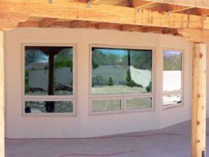A wall with windows and a wooden beam.