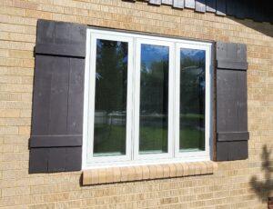 Window with wooden shutters on brick